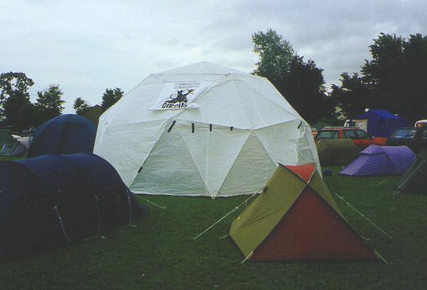 [picture of dome amongst tents under ominously grey sky]